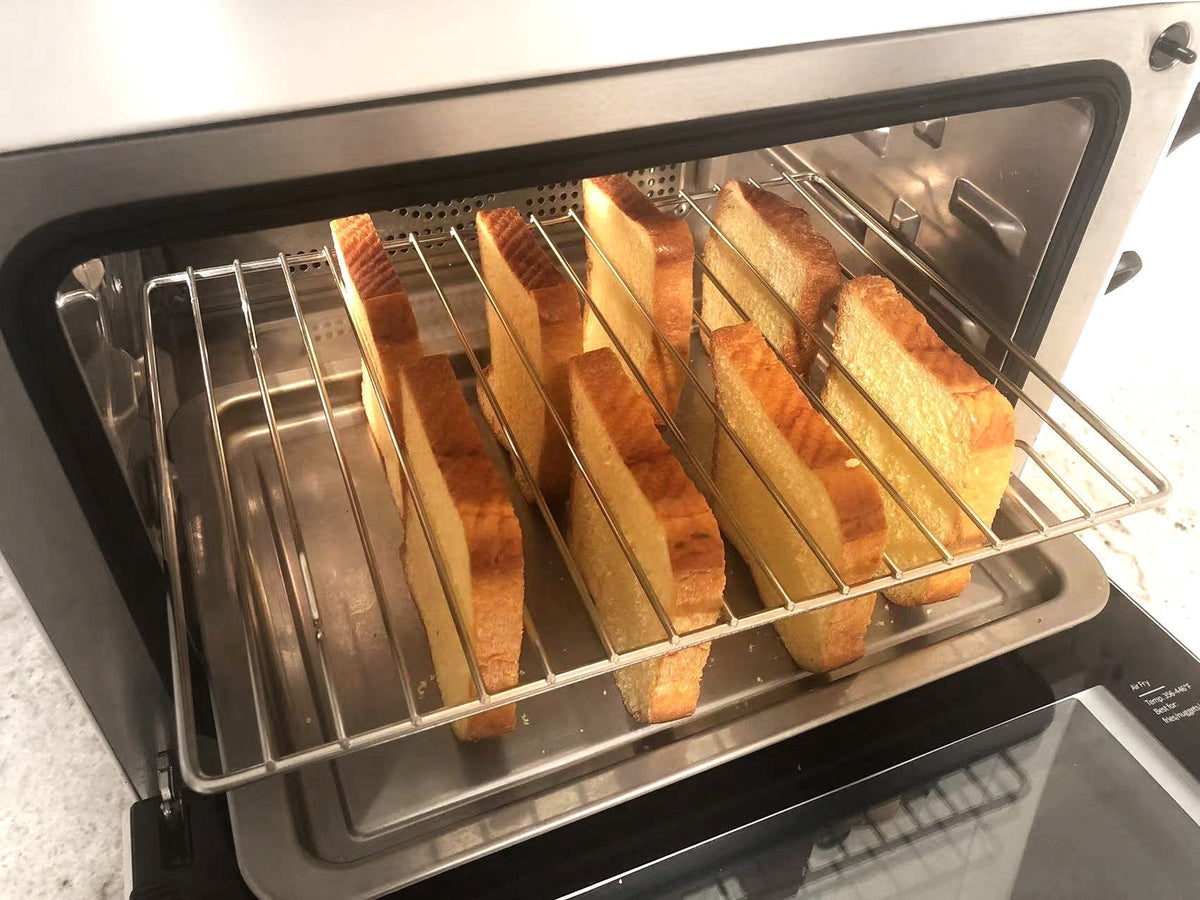 Golden toast slices on a wire rack inside an open countertop convection oven